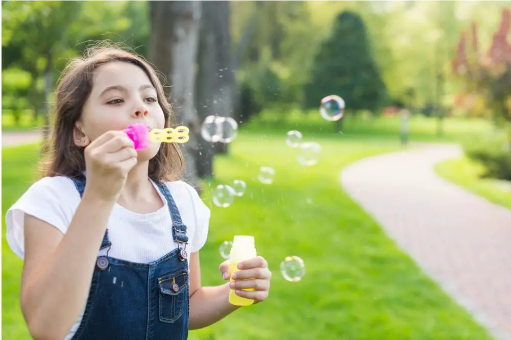 Jugar con burbujas soplando es una actividad divertida y feliz que también puede representar la alegría de tu infancia